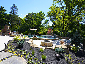 exclusive backyard escape featuring landscaping, water features and lighting