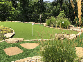 putting green made of artificial turf, edged with Flagstone and weathered boulders