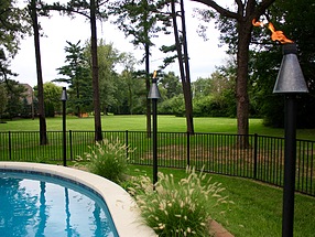 landscape design, lighting, st. louis landscape, tiki torches, copper, pool, hameln grass, fence